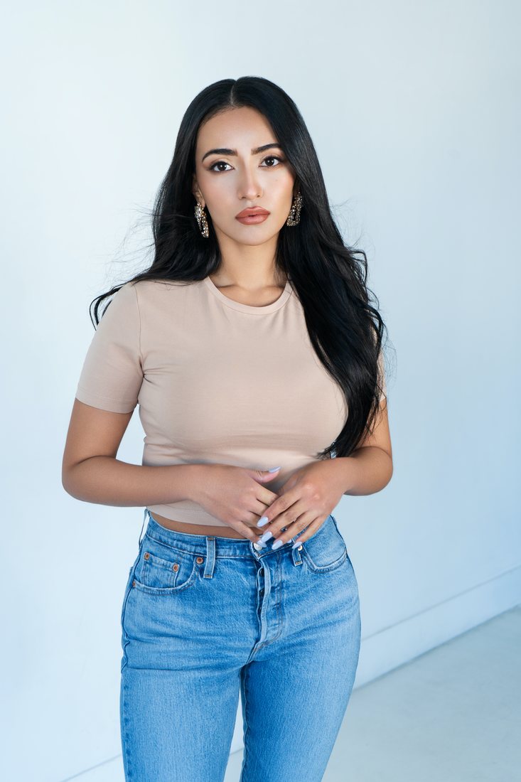 Portrait, woman in a beige top and jeans